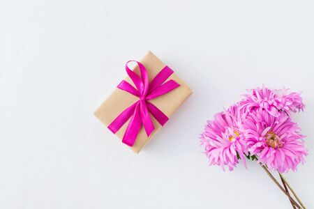 Pink flowers with gift box on white background empty space for your text, top viewの写真素材