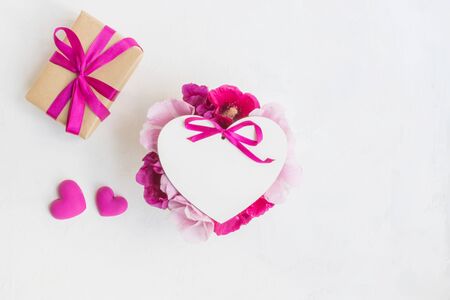 Frame with pink flowers with gift box on light background empty space for your text, top viewの写真素材