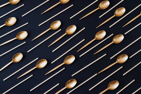 Party decoration background. Golden disposable dishes on dark wooden backgroundの写真素材