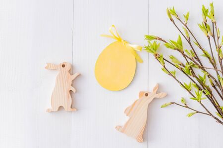 Flat lay easter composition with green buds on branches and eggs on a white wooden backgroundの写真素材