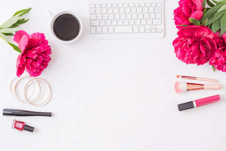 Flat lay blogger or freelancer workspace with a keyboard, red peonies on a white backgroundの写真素材
