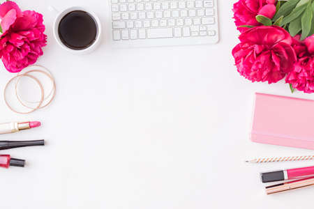 Flat lay blogger or freelancer workspace with a notebook, keyboard, red peonies on a white backgroundの写真素材