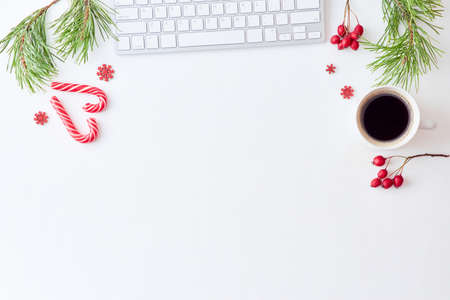 Flat lay christmas home office desk with pine branches and keyboard, christmas decorations on a...