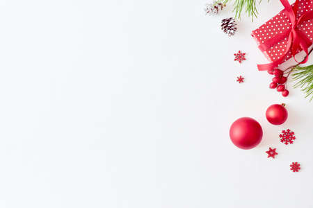Flat lay christmas border with pine branche, balls and berries on a white backgroundの写真素材