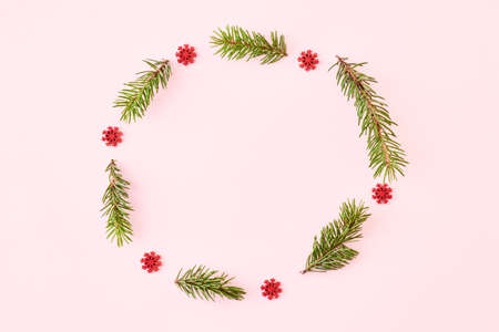 Flat lay christmas frame with spruce branches and snowflakes on a color backgroundの写真素材