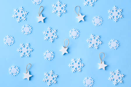 Flat lay christmas pattern with snowflakes and stars on a blue backgroundの写真素材