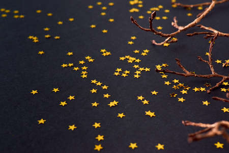 Border with gold christmas branch and golden confetti on a dark background