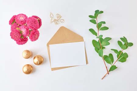 Mockup white greeting card and envelope with branches with green leaves on a light background