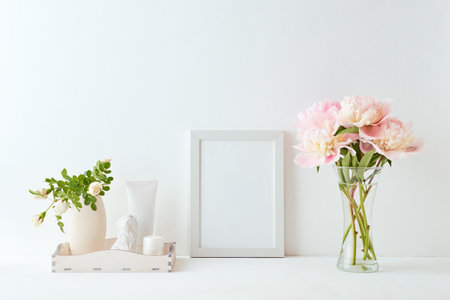 Home interior with decor elements. White frame, pink peonies in a vase, interior decorationの写真素材