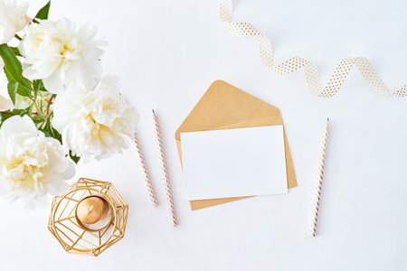 Mockup wedding invitation and envelope with white peonies on a white background