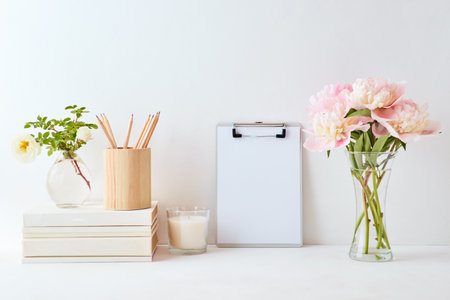 Home interior with decor elements. Mockup clipboard, pink peonies in a vase, interior decorationの写真素材