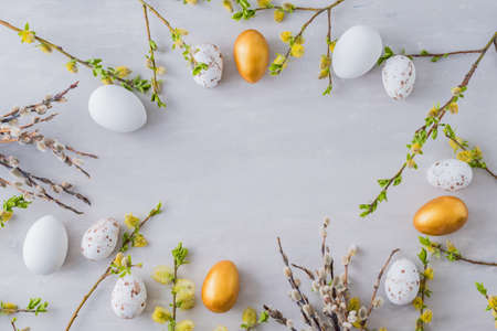 Flat lay easter composition with a willow branch and eggs on a gray backgroundの写真素材