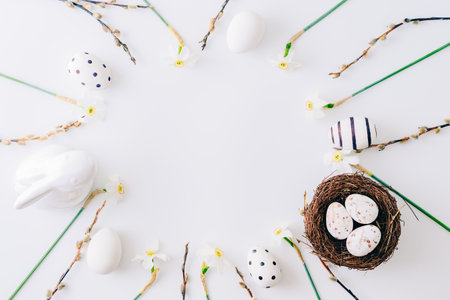 Flat lay easter composition with a white daffodils and eggs on a white backgroundの写真素材