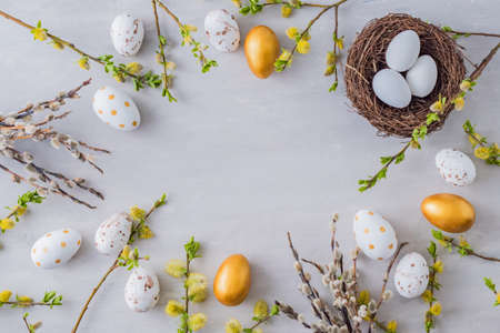 Flat lay easter composition with a willow branch and eggs on a gray backgroundの写真素材