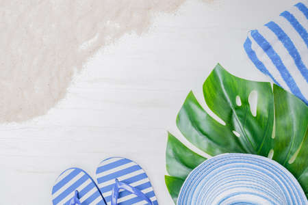 Flat lay composition with a summer hat and flip flops on a light backgroundの写真素材