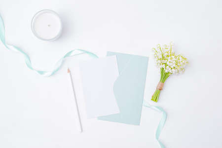 Mockup white wedding invitation and envelope with white flowers on a white background