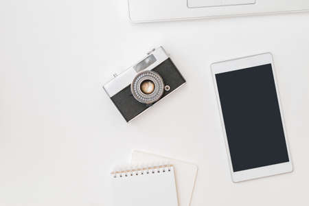 Flat lay mockup smartphone blank screen, laptop, vintage camera on a white backgroundの写真素材