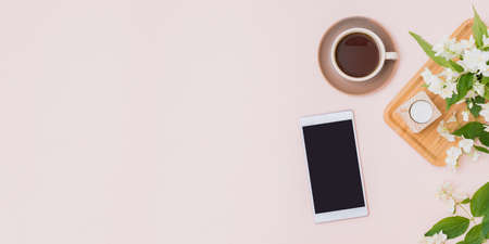 Flat lay composition with a cup of coffee and jasmine flowers on a color background