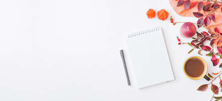 Mockup white notebook and colorful autumn leaves, scarf and a cup of coffee on a white background