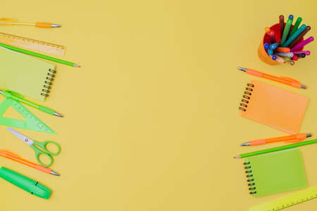 Flat lay composition with school supplies on a yellow background