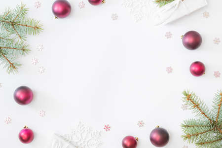 Flat lay frame with fir branches, christmas baubles decoration and gift box on a white background
