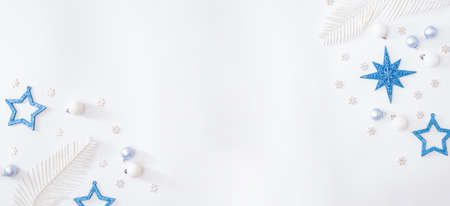 Flat lay frame with christmas baubles decoration and snowflakes on a white background