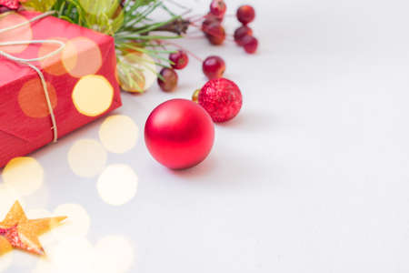 Frame with red christmas decoration, pine branches and gift box on a white backgroundの写真素材