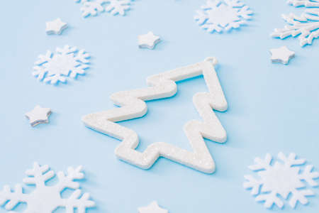 Flat lay pattern with christmas balls and snowflakes on a blue background