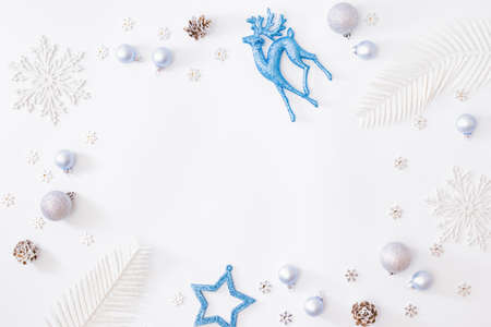 Flat lay frame with christmas baubles decoration and snowflakes on a white backgroundの写真素材