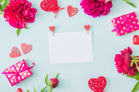 Mockup white greeting card with red peonies on a light backgroundの写真素材