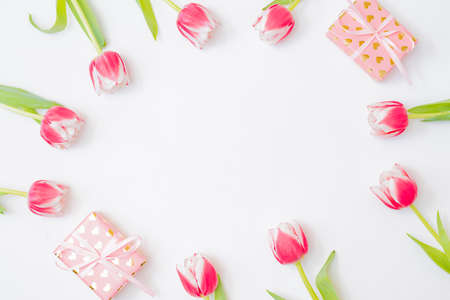Flat lay valentines day frame with pink tulips and gift box on a white backgroundの写真素材
