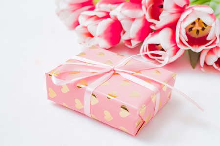 Valentines day composition with pink tulips and gift box on a white background