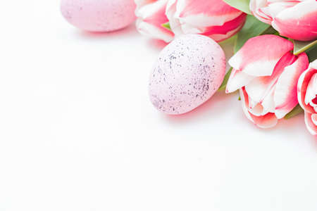 Easter composition with pink tulips and eggs on white background
