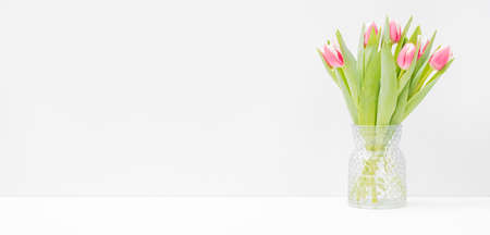 Home interior decor elements. Pink tulips in a vase on a light background