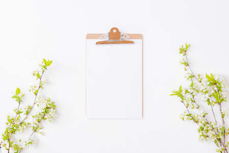 Mockup clipboard with blossom cherry branches and green leaves on a white backgroundの写真素材