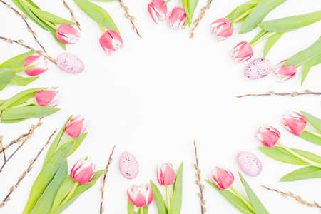Flat lay easter composition with pink tulips and eggs on white background
