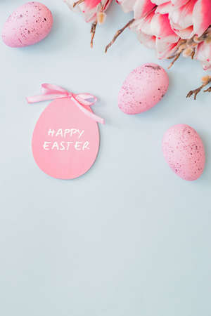 Flat lay easter composition with pink tulips and eggs on color background