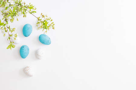Flat lay easter composition with spring flowers and eggs on white backgroundの写真素材
