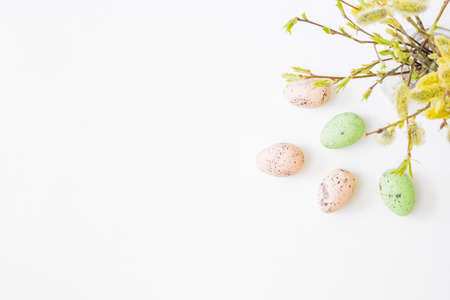 Flat lay easter composition with willow branches in a vase and easter eggs on a light background