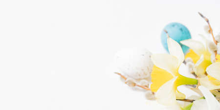 Easter composition with daffodils and eggs on white background