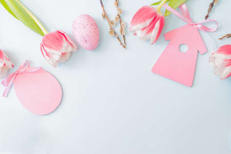 Flat lay easter composition with pink tulips and eggs on color background