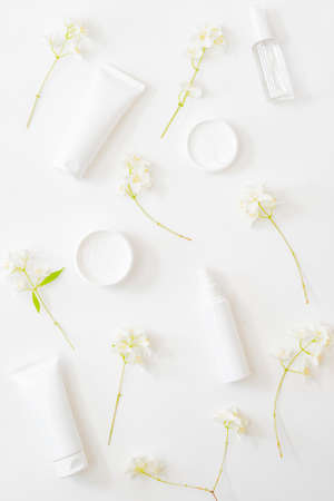 Flat lay composition with cosmetics and jasmine flowers on a light backgroundの写真素材