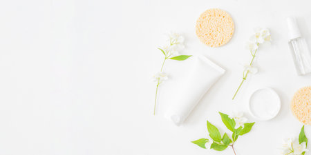 Flat lay composition with cosmetics and jasmine flowers on a light backgroundの写真素材