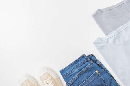 Flat lay summer composition with jeans and sneakers on a white background