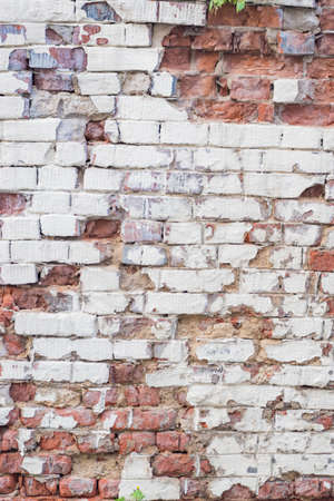 Vertical background with red brick wall with peeling plasterの写真素材