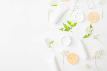 Flat lay composition with cosmetics and jasmine flowers on a light backgroundの写真素材
