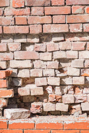 Vertical background with red brick wall with peeling plasterの写真素材
