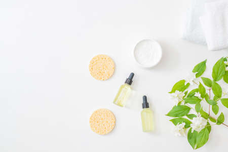 Flat lay composition with cosmetics and jasmine flowers on a light backgroundの写真素材