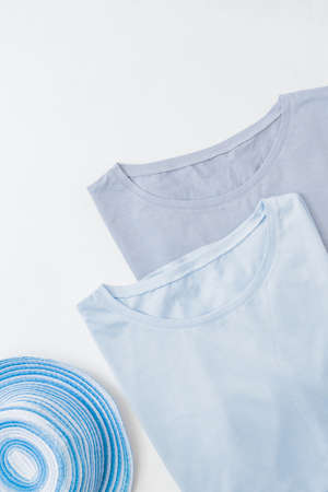 Flat lay blank folded blue t-shirts on a white backgroundの写真素材