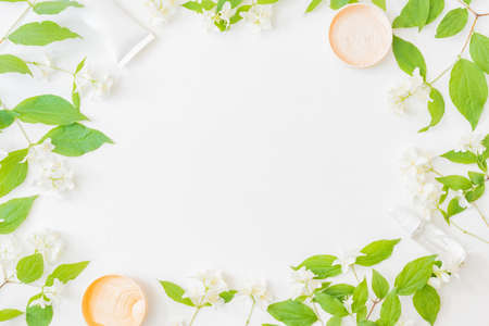 Flat lay composition with cosmetics and jasmine flowers on a light backgroundの写真素材